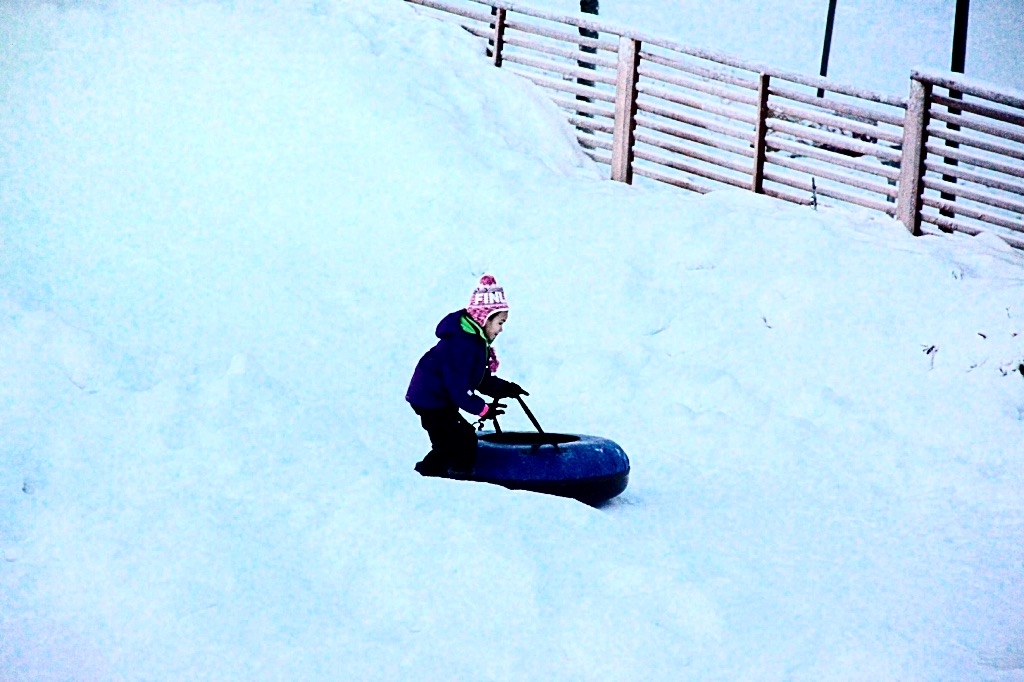 Petite fille glissant en descente à Rovaniemi